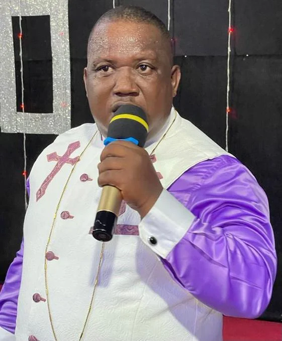 Anthony Nkumbe speaking into a microphone at a ministry gathering